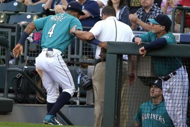 Seattle Mariners' Ketel Marte is helped into the dugout by Mariners trainer Rick Griffin as Marte leaves the baseball game at the start of the fourth inning against the Houston Astros, Friday, July 15, 2016, in Seattle. Marte was injured as he was tagged out sliding into third base in the third inning. (AP Photo/Ted S. Warren)