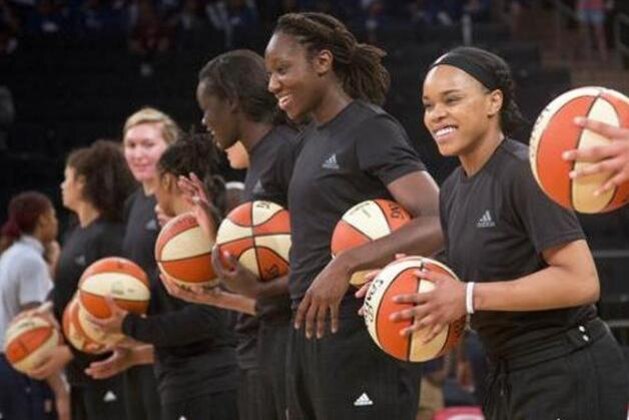 FILE - In this Wednesday, July 13, 2016 file photo, members of the New York Liberty basketball team await the start of a game against the Atlanta Dream, in New York. The WNBA has fined the New York Liberty, Phoenix Mercury and Indiana Fever and their players for wearing plain black warm-up shirts in the wake of recent shootings by and against police officers. All three teams were fined $5,000 and each player was fined $500. While the shirts were the Adidas brand - the official outfitter of the league - WNBA rules state that uniforms may not be altered in any way. (AP Photo/Mark Lennihan, File)
