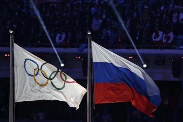 FILE - In this Feb. 23, 2014 file photo the Russian national flag, right, flies after it is hoisted next to the Olympic flag during the closing ceremony of the 2014 Winter Olympics in Sochi, Russia.  On Monday, July 18, 2016 a report on Russian doping by investigator Richard McLaren is to be released in Toronto.  (AP Photo/Matthias Schrader, file)