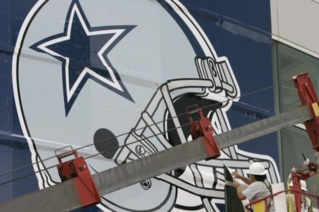 Workers hang a Dallas Cowboys logo on the Alamodome in preparation for football training camp in San Antonio, Tuesday, July 24, 2007. The Cowboys hold their first workout Wednesday. (AP Photo/Eric Gay)