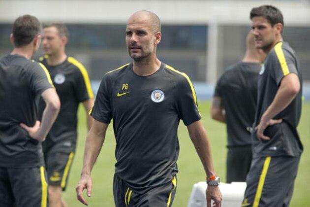 Manchester City manager Pep Guardiola, center, leaves the field after his team's training session at the Olympic Sports Center Stadium in Beijing, Sunday, July 24, 2016. Manchester City will play a friendly soccer match against Manchester United in Beijing on Monday night. (AP Photo/Mark Schiefelbein)