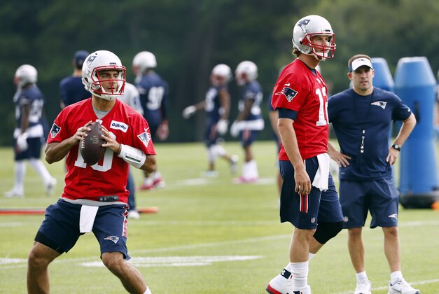 Jun 7, 2016; Foxborough, MA, USA; New England Patriots quarterback Jimmy Garoppolo (10) drops back to pass as offensive coordinator Josh McDaniels and quarterback Tom Brady (12) look on during mini camp at Gillette Stadium. Mandatory Credit: Winslow Townson-USA TODAY Sports