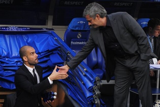 FC Barcelona's coach Pep Guardiola, left, shakes hands with Real Madrid's coach Jose Mourinho, from Portugal, ahead of their semifiinal first leg Champions League soccer match at the Bernabeu stadium in Madrid, Spain, Wednesday, April 27, 2011. (AP Photo/Manu Fernandez)