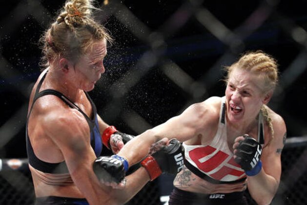 Valentina Shevchenko, right, of Kyrgyzstan, follows through on a punch to Holly Holm during a women's bantamweight mixed martial arts bout in Chicago, Saturday, July 23, 2016. (AP Photo/Nam Y. Huh)