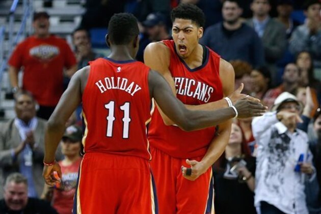 New Orleans Pelicans forward Anthony Davis, right, celebrates with guard Jrue Holiday (11) during the second half of an NBA basketball game against the Utah Jazz in New Orleans, Tuesday, Dec. 16, 2014. The Pelicans won 119-111. (AP Photo/Jonathan Bachman)