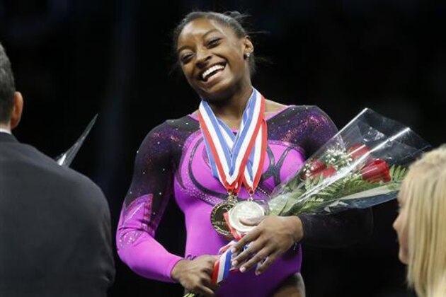 FILE - In this Aug. 23, 2014, file photo, Simone Biles smiles after getting her gold medal at the gymnastics U.S. Championships in Pittsburgh. There’s money to be made if you end up standing atop the podium at the Olympics with “The Star Spangled Banner” playing and your sport’s most coveted prize draped over your neck.  (AP Photo/Keith Srakocic, File)