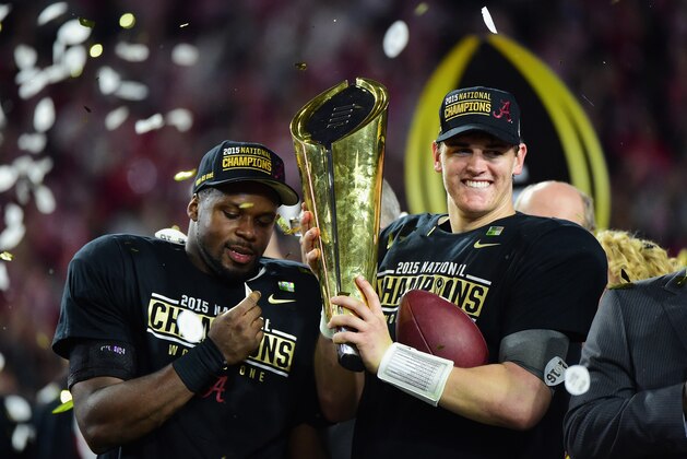GLENDALE, AZ - JANUARY 11:  Jake Coker #14 of the Alabama Crimson Tide celebrates by hoisting the College Football Playoff National Championship Trophy after defeating the Clemson Tigers in the 2016 College Football Playoff National Championship Game at University of Phoenix Stadium on January 11, 2016 in Glendale, Arizona.  The Crimson Tide defeated the Tigers with a score of 45 to 40.  (Photo by Harry How/Getty Images)