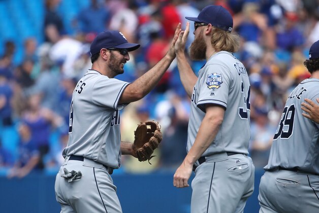 TORONTO, CANADA - JULY 27: Adam Rosales #9 of the San Diego Padres celebrates their victory with Andrew Cashner #34 during MLB game action against the Toronto Blue Jays on July 27, 2016 at Rogers Centre in Toronto, Ontario, Canada. (Photo by Tom Szczerbowski/Getty Images)