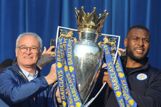 Leicester City's manager Claudio Ranieri. left, and captain Wes Morgan hold up the trophy at Victoria Park during the victory parade to celebrate winning the English Premier league title in Leicester, England, Monday, May 16, 2016. (AP Photo/Rui Vieira)