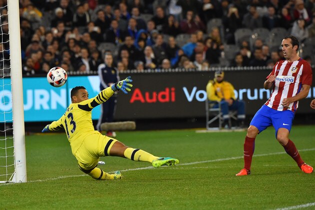 Atletico Madrid's Diego Godin (R) fires the ball past Tottenham Hotspur goalkeeper Michel Vorm (L) to score during the International Champions Cup football match between English Premier League team Tottenham Hotspur and Spanish club Atletico Madrid in Melbourne on July 29, 2016. / AFP / Paul Crock / --IMAGE RESTRICTED TO EDITORIAL USE - STRICTLY NO COMMERCIAL USE--        (Photo credit should read PAUL CROCK/AFP/Getty Images)