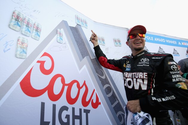 LONG POND, PA - JULY 29:  Martin Truex Jr, driver of the #78 Furniture Row Toyota, signs the Coors Light Pole Award banner after qualifying for the NASCAR Sprint Cup Series Pennsylvania 400 at Pocono Raceway on July 29, 2016 in Long Pond, Pennsylvania.  (Photo by Adam Glanzman/Getty Images)