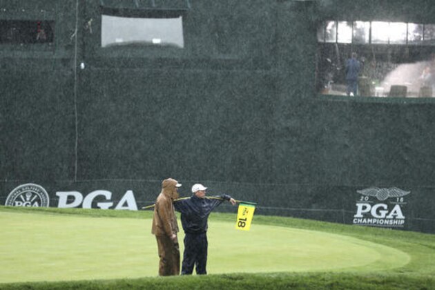 Members of the grounds crew stand on the 18th green during a weather delay in the third round of the PGA Championship golf tournament at Baltusrol Golf Club in Springfield, N.J., Saturday, July 30, 2016. (AP Photo/Seth Wenig)