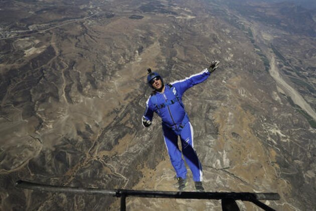 In this Monday, July 25, 2016 photo, skydiver Luke Aikins jumps from a helicopter during his training in Simi Valley, Calif. After months of training, this elite skydiver says he's ready to leave his chute in the plane when he bails out 25,000 feet above Simi Valley, Calif., on Saturday, July 30. That's right, no parachute, no wingsuit and no fellow skydiver with an extra one to hand him in mid-air. (AP Photo/Jae C. Hong, File)
