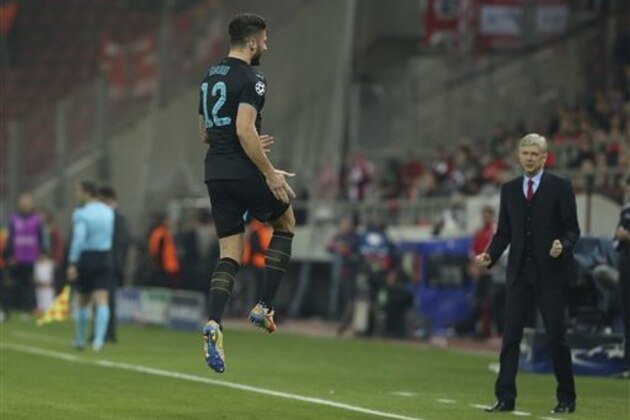Arsenal's Olivier Giroud celebrates after scoring is third goal as Arsenal's manager Arsene Wenger watches during a Champions League Group F soccer match between Olympiakos and Arsenal at the Georgios Karaiskakis stadium in Piraeus port, near Athens, Wednesday, Dec. 9, 2015. (AP Photo/Petros Giannakouris)