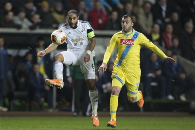 Swansea's Ashley Williams, left, keeps the ball from Napoli's Goran Pandev during their Europa League round of 32 first leg soccer match at the Liberty Stadium, Swansea, Wales, Thursday Feb. 20, 2014. (AP Photo/Jon Super)