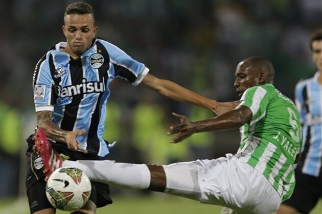 Luan of Brazil's Gremio, left, and Juan David Valencia of Colombia's Atletico Nacional vie for the ball during a Copa Libertadores soccer match in Medellin, Colombia, Wednesday, April 2, 2014. (AP Photo/Ricardo Mazalan)