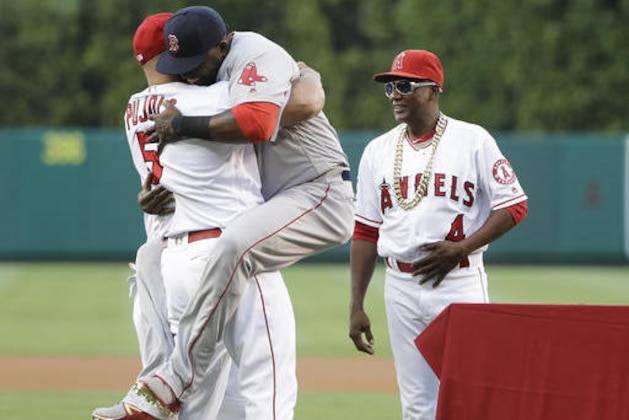 Boston Red Sox's David Ortiz is hugged by Los Angeles Angels' Albert Pujols, left, during a presentation as Angels infield coach Alfredo Griffin watches before a baseball game, Thursday, July 28, 2016, in Anaheim, Calif. (AP Photo/Jae C. Hong)