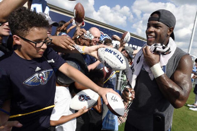 Tennessee Titans running back DeMarco Murray, right, signs autographs for fans following NFL football training camp Sunday, July 31, 2016, in Nashville, Tenn. (AP Photo/Mark Zaleski)