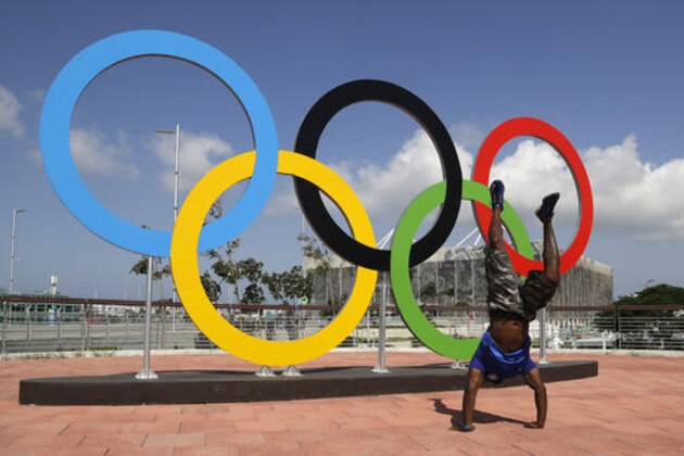 A man performs a handstand in front of the Olympic rings three days before the 2016 Summer Olympics in Rio de Janeiro, Brazil, Tuesday, Aug. 2, 2016. (AP Photo/Dmitri Lovetsky)