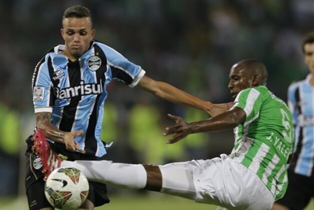 Luan of Brazil's Gremio, left, and Juan David Valencia of Colombia's Atletico Nacional vie for the ball during a Copa Libertadores soccer match in Medellin, Colombia, Wednesday, April 2, 2014. (AP Photo/Ricardo Mazalan)