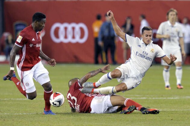 Bayern Munich's Arturo Vidal charges Real Madrid' Lucas Vazquez, right, as Bayern Munich's David Alaba, left, looks on during the first half of their friendly soccer match Wednesday, Aug. 3, 2016, in East Rutherford, N.J. (AP Photo/Bill Kostroun)