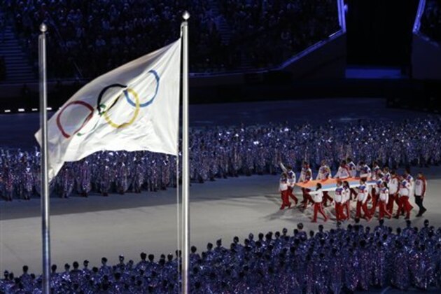 Flag bearers carry the Russian national flag, as the Olympic flag flies during the closing ceremony of the 2014 Winter Olympics, Sunday, Feb. 23, 2014, in Sochi, Russia. (AP Photo/Gregorio Borgia)