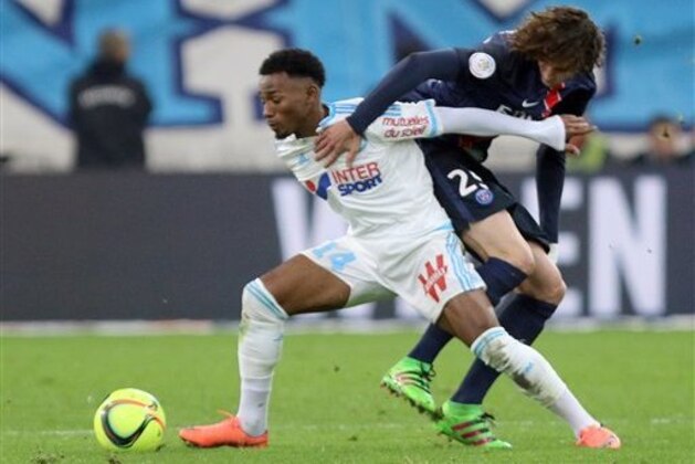Marseille's Georges-Kevin NKoudou, left,  challenges for the ball with Paris Saint Germain's Adrien Rabiot, during the League One soccer match between Marseille and Paris Saint-Germain, at the Velodrome Stadium, in Marseille, southern France, Sunday, Feb. 7, 2016. (AP Photo/Claude Paris)
