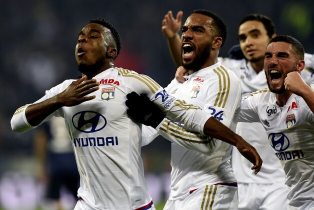Olympique Lyonnais' French forward Maxwell Cornet (L) is congratuled by teamates after scoring during the French Ligue1 football match between Olympique Lyonnais and Paris Saint-Germain, on February 28, 2016 at the New stadium in Decines-Charpieu near Lyon, southeastern France.                                    AFP PHOTO/PHILIPPE DESMAZES / AFP / PHILIPPE DESMAZES        (Photo credit should read PHILIPPE DESMAZES/AFP/Getty Images)