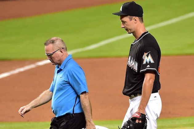 Jul 30, 2016; Miami, FL, USA; Miami Marlins starting pitcher Colin Rea (right) walks back to the dugout with a member of the medical staff after Rea injured his are during the fourth inning against the St. Louis Cardinals at Marlins Park. Mandatory Credit: Steve Mitchell-USA TODAY Sports