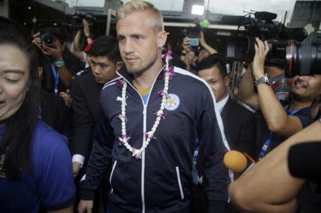 Leicester City's Kasper Schmeichel, center, leaves Suvarnabhumi airport in Bangkok, Thailand, Wednesday, May 18, 2016. English Premier League champions Leicester city arrived to present their trophy to the Thai people. Leicester is owned by Thai duty free group King Power. (AP Photo/Sakchai Lalit)