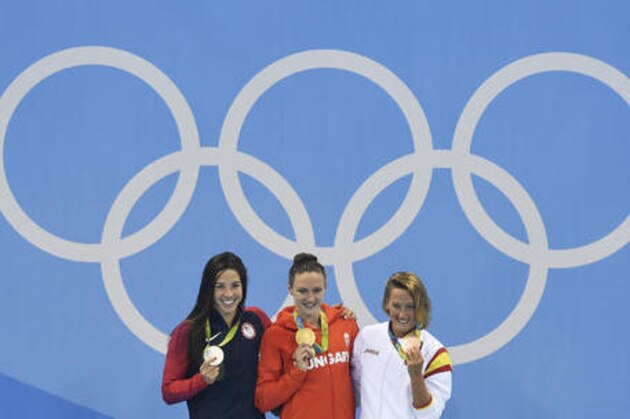 Hungary's gold medal winner Katinka Hosszu is flanked by United States' silver medal winner Maya DiRado, left, and Spain's bronze medal winner Mireia Belmonte Garcia during the ceremony for the women's 400-meter individual medley final during the swimming competitions at the 2016 Summer Olympics, Saturday, Aug. 6, 2016, in Rio de Janeiro, Brazil. (AP Photo/Martin Meissner)
