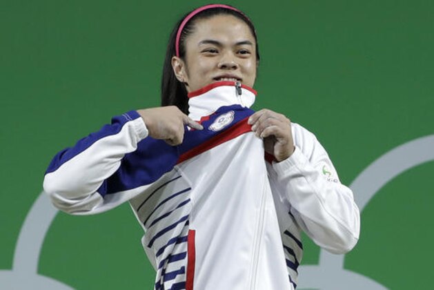 Hsu Shu-Ching, of Taiwan, celebrates on the winner's stand after winning the gold medal in the women's 53kg weightlifting competition at the 2016 Summer Olympics in Rio de Janeiro, Brazil, Sunday, Aug. 7, 2016. (AP Photo/Mike Groll)