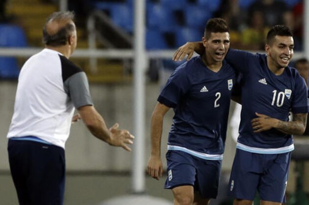 Argentina's Angel Correa, right, celebrates with teammate Argentina's Lautaro Giannetti after scoring his team's first goal during a group D match of the men' s Olympic football tournament between Argentina and Algeria at the Rio Olympic Stadium in Rio de Janeiro, Brazil, Sunday Aug. 7, 2016. At left is Argentina's coach Julio Olarticoechea.(AP Photo/Leo Correa)