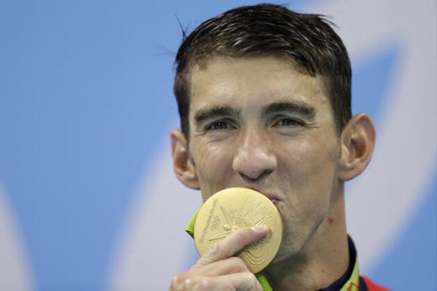 United States' Michael Phelps kisses his gold medal after the men's 4x100-meter freestyle final during the swimming competitions at the 2016 Summer Olympics, Monday, Aug. 8, 2016, in Rio de Janeiro, Brazil. (AP Photo/Michael Sohn)