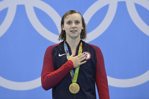 USA's Katie Ledecky listens to the US national anthem while posing on the podium with her gold medal after she won the Women's 400m Freestyle Final during the swimming event at the Rio 2016 Olympic Games at the Olympic Aquatics Stadium in Rio de Janeiro on August 7, 2016.   / AFP / CHRISTOPHE SIMON        (Photo credit should read CHRISTOPHE SIMON/AFP/Getty Images)