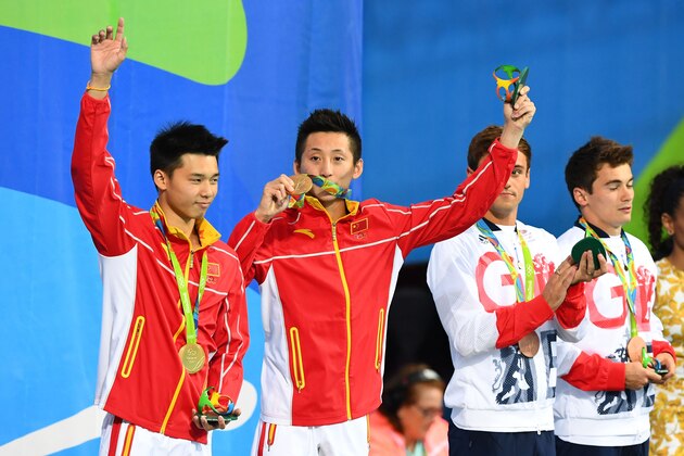 RIO DE JANEIRO, BRAZIL - AUGUST 08:  Gold medalists Aisen Chen and Yue Lin of China celebrate on the podium during the medal ceremony for the Men's Diving Synchronised 10m Platform Final on Day 3 of the Rio 2016 Olympic Games at Maria Lenk Aquatics Centre on August 8, 2016 in Rio de Janeiro, Brazil.  (Photo by Quinn Rooney/Getty Images)