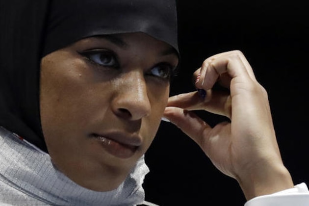 Ibtihaj Muhammad od the United States adjusts her hijab prior to competing with Olena Kravatska of Ukraine in the women's individual saber fencing event at the 2016 Summer Olympics in Rio de Janeiro, Brazil, Monday, Aug. 8, 2016. (AP Photo/Andrew Medichini)
