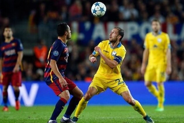 Barcelona's Adriano, left, and BATE's Igor Stasevich eye the ball during the Champions League Group E soccer match between FC Barcelona and BATE Borisov at the Camp Nou stadium in Barcelona, Spain, Wednesday, Nov. 4, 2015. (AP Photo/Manu Fernandez)