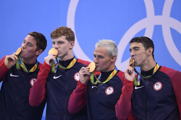 (FromL) USA's Conor Dwyer, USA's Townley Haas, USA's Ryan Lochte and USA's Michael Phelps kiss their gold medal on the podium after they won the Men's 4x200m Freestyle Relay Final during the swimming event at the Rio 2016 Olympic Games at the Olympic Aquatics Stadium in Rio de Janeiro on August 9, 2016. / AFP / GABRIEL BOUYS (Photo credit should read GABRIEL BOUYS/AFP/Getty Images) (FromL) USA's Conor Dwyer, USA's Townley Haas, USA's Ryan Lochte and USA's Michael Phelps kiss their gold medal on the podium after they won the Men's 4x200m Freestyle Relay Final during the swimming event at the Rio 2016 Olympic Games at the Olympic Aquatics Stadium in Rio de Janeiro on August 9, 2016. / AFP / GABRIEL BOUYS (Photo credit should read GABRIEL BOUYS/AFP/Getty Images)