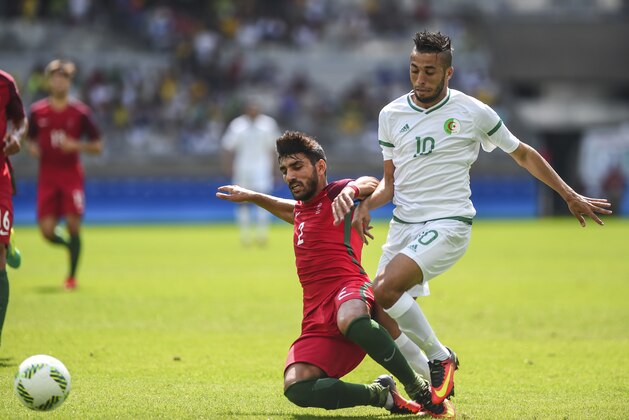 BELO HORIZONTE, BRAZIL - AUGUST 10: Ricardo Esgaio of Portugal and Abderrahmane Meziane of Algeria battle for the ball during the Men's Group D match between Algeria and Portugal on Day 5 of the Rio 2016 Olympic Games at Mineirao Stadium on August 10, 2016 in Belo Horizonte, Brazil. (Photo by Pedro Vilela/Getty Images)