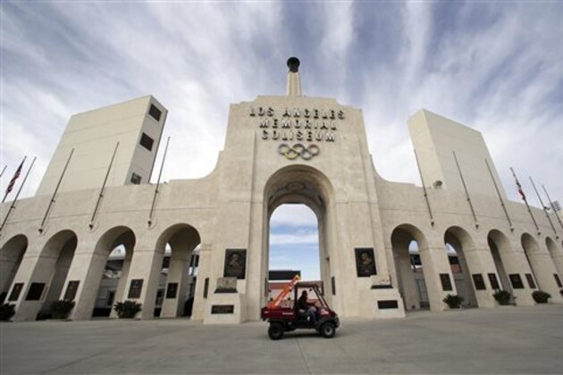 A worker rides past the entrance of The Los Angeles Memorial Coliseum on Wednesday, Jan. 13, 2016. NFL owners voted Tuesday night to allow the St. Louis Rams to move to a new stadium just outside Los Angeles. The Rams, based in the LA area from 1946-94, will play in a temporary facility, probably the Los Angeles Coliseum, until the new stadium is ready, most likely for the 2019 season. (AP Photo/Nick Ut)