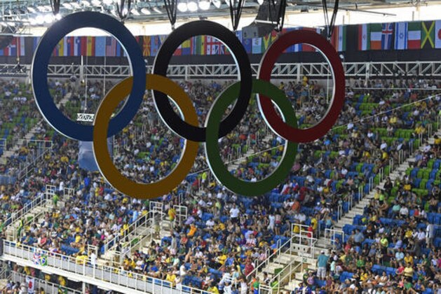 The Olympic rings hang over the spectators of the swimming competitions at the 2016 Summer Olympics, Sunday, Aug. 7, 2016, in Rio de Janeiro, Brazil. (AP Photo/Martin Meissner)