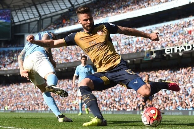 Arsenal's French striker Olivier Giroud (R) crosses the ball by Manchester City's Argentinian defender Nicolas Otamendi during the English Premier League football match between Manchester City and Arsenal at the Etihad Stadium in Manchester, north west England, on May 8, 2016. / AFP / PAUL ELLIS / RESTRICTED TO EDITORIAL USE. No use with unauthorized audio, video, data, fixture lists, club/league logos or 'live' services. Online in-match use limited to 75 images, no video emulation. No use in betting, games or single club/league/player publications.  /         (Photo credit should read PAUL ELLIS/AFP/Getty Images)