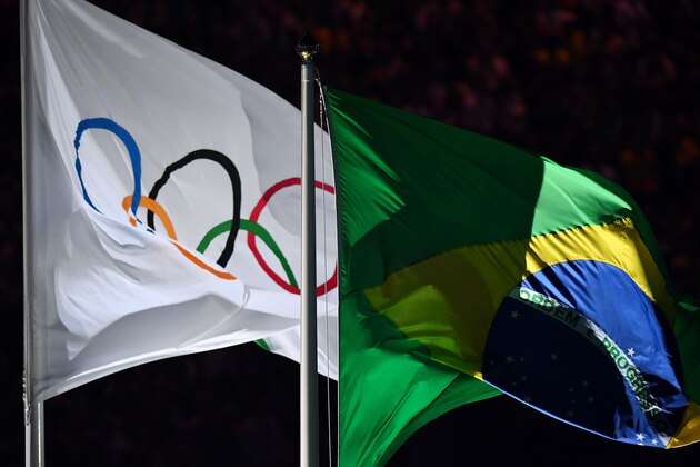 The Olympic flag is raised next to the Brazilian flag during the opening ceremony of the Rio 2016 Olympic Games at the Maracana stadium in Rio de Janeiro on August 5, 2016. / AFP / GABRIEL BOUYS        (Photo credit should read GABRIEL BOUYS/AFP/Getty Images)