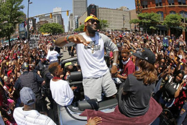 FILE - In this June 22, 2016, file photo, Cleveland Cavaliers' LeBron James, center, stands in the back of a Rolls-Royce as it makes it way through the crowd during a parade in downtown Cleveland celebrating the team's NBA championship. A person familiar with the contract says James has agreed to a three-year, $100 million contract with the Cavaliers. The person says James, who recently led the Cavs to an NBA title--the first for a Cleveland sport team in 52 years--will soon sign the deal. The person spoke to the Associated Press Thursday on condition of anonymity because some details of the deal need to be finalized. (AP Photo/Gene J. Puskar, File)