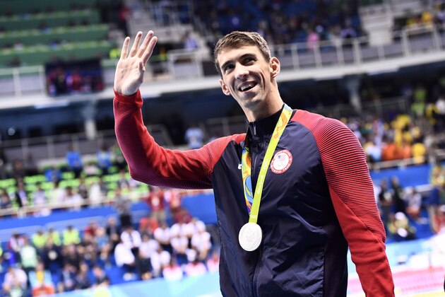 Silver medallist USA's Michael Phelps waves during the medal ceremony of the Men's 100m Butterfly Final during the swimming event at the Rio 2016 Olympic Games at the Olympic Aquatics Stadium in Rio de Janeiro on August 12, 2016.   / AFP / CHRISTOPHE SIMON        (Photo credit should read CHRISTOPHE SIMON/AFP/Getty Images)