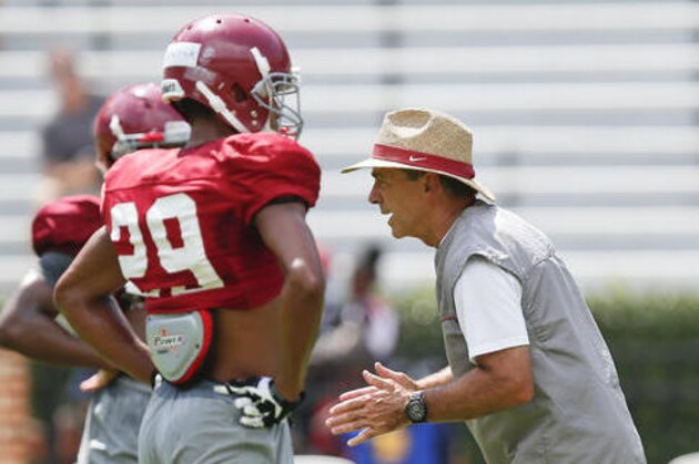 Alabama coach Nick Saban, right, demonstrates drills to his players during an NCAA college football practice, Sunday, Aug. 7, 2016, in Tuscaloosa, Ala. (AP Photo/Brynn Anderson)