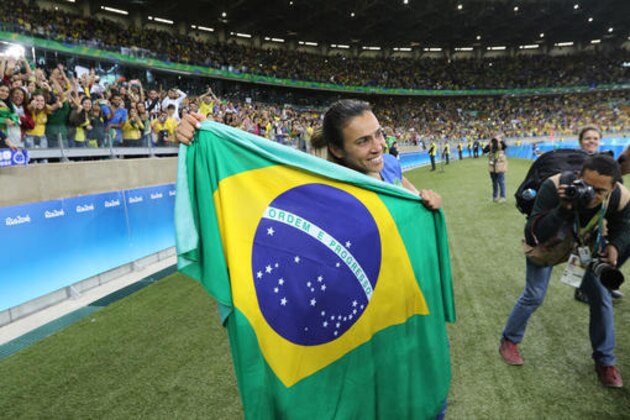 Brazil's Marta poses with a Brazilian flag after defeating Australia in a penalty shootout of a quarter-final match of the women's Olympic football tournament between Brazil and Australia at the Mineirao Stadium in Belo Horizonte, Brazil, Saturday, Aug. 13, 2016. (AP Photo/Eugenio Savio)