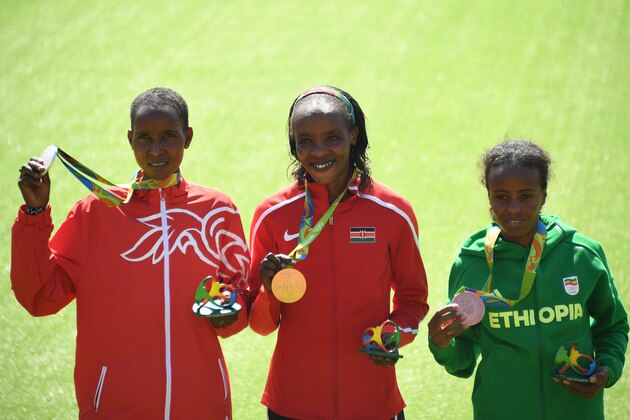 (LtoR) Bahrain's Eunice Jepkirui Kirwa (silver medal) Kenya's Jemima Jelagat Sumgong (gold medal) and Ethiopia's Mare Dibaba (bronze medal) pose during the podium ceremony for the Women's Marathon during the athletics event at the Rio 2016 Olympic Games at Sambodromo in Rio de Janeiro on August 14, 2016.   / AFP / POOL / Johannes EISELE        (Photo credit should read JOHANNES EISELE/AFP/Getty Images)
