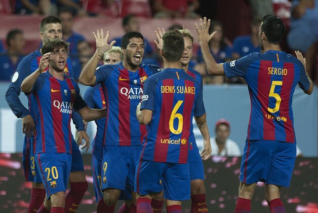 Barcelona's Uruguayan forward Luis alberto Suarez (C) celebrates with his teammates after scoring during the first leg of the Spanish Supercup football match between Sevilla FC and FC Barcelona at the Ramon Sanchez Pizjuan stadium in Sevilla on August 14, 2016. / AFP / JORGE GUERRERO        (Photo credit should read JORGE GUERRERO/AFP/Getty Images)